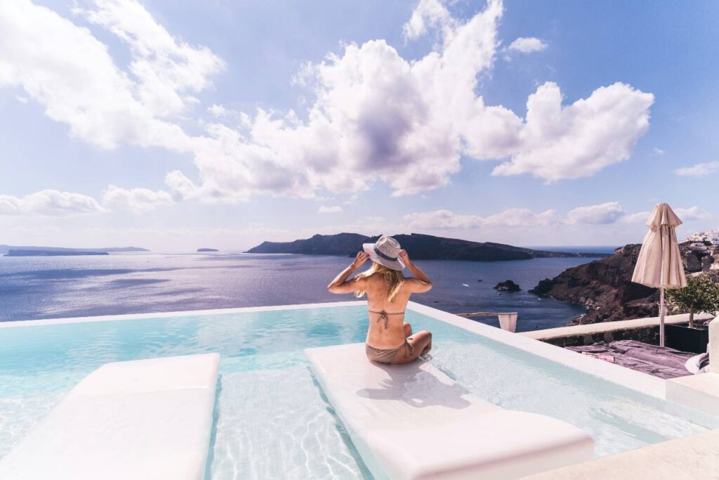 woman sitting by a pool overlooking the ocean